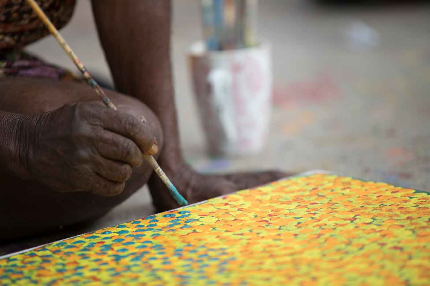 An Aboriginal artist painting at Mangkaja Arts Resource Agency.