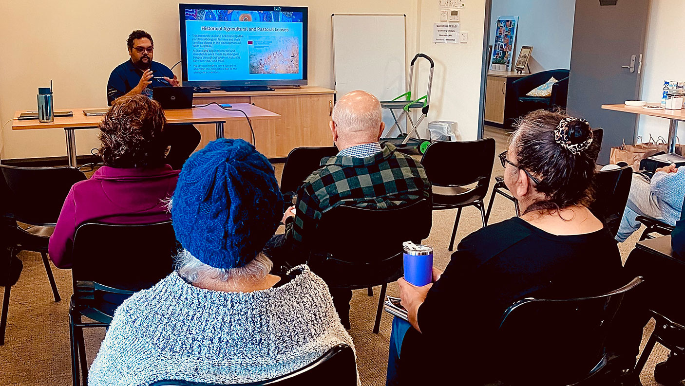 A small group of people listening to the presenter at an AHWA information session