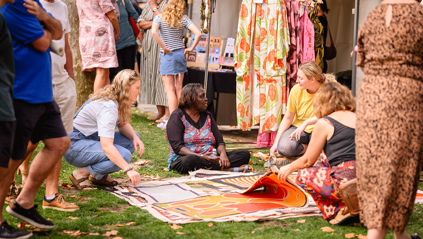 Artists and shoppers looking at painted canvas' at the Revealed art market